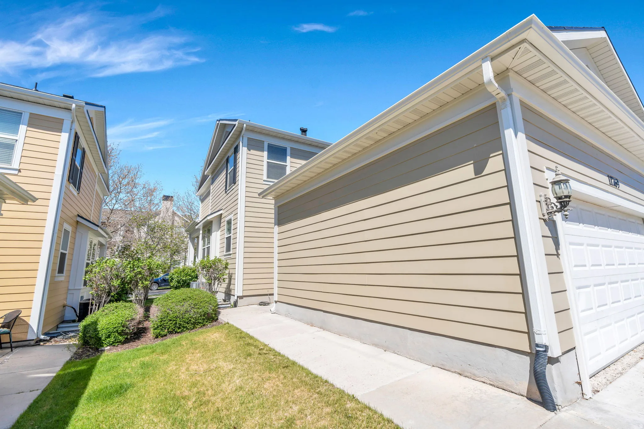 View of property exterior with a garage and a yard