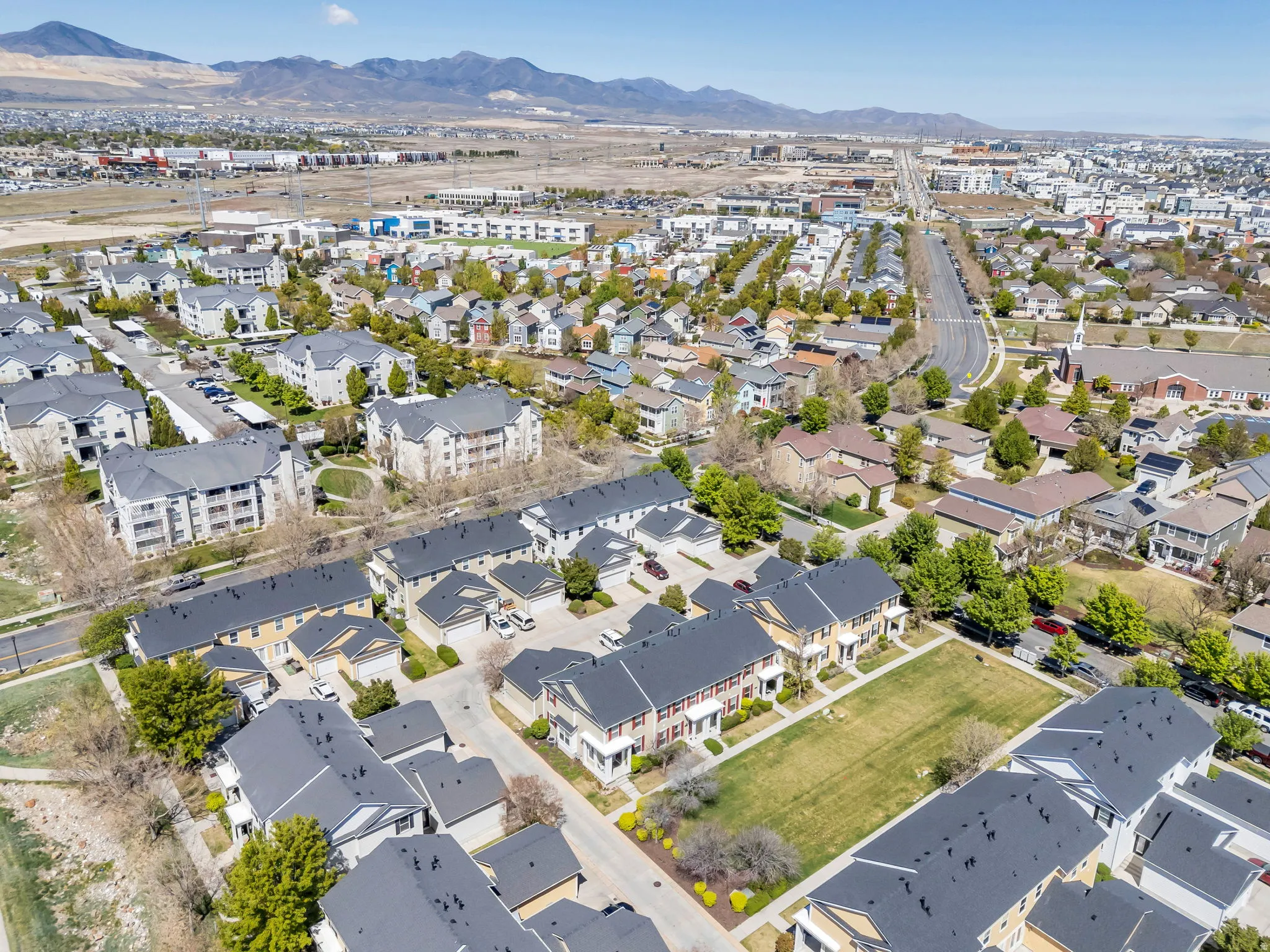 Aerial view of property and surrounding area with mountains and nearby suburban area