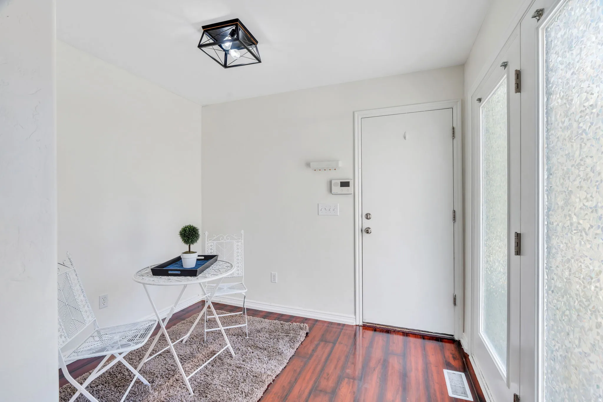 Foyer featuring dark wood finished floors and baseboards