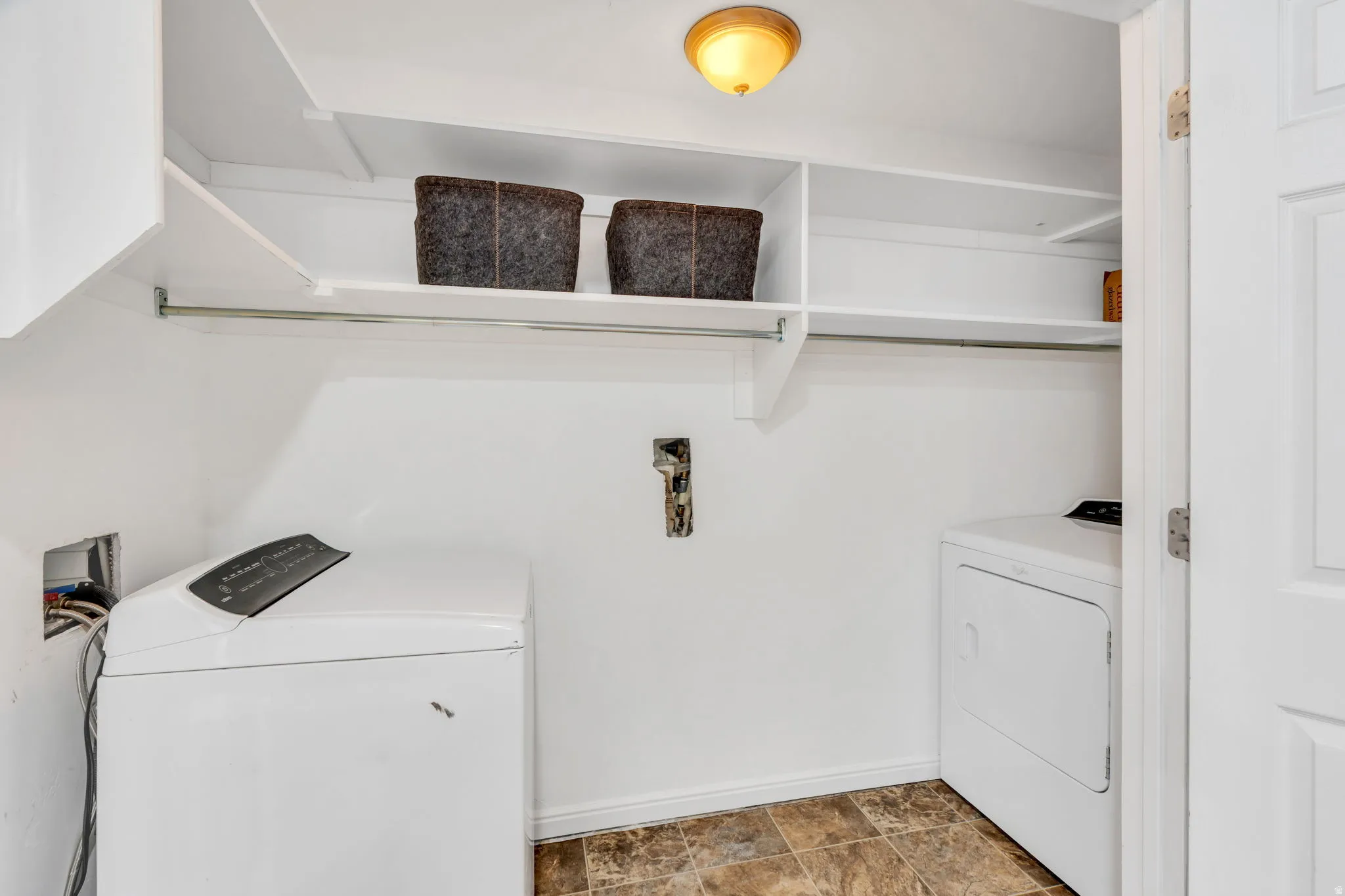 Laundry room with washer and dryer and stone finish flooring
