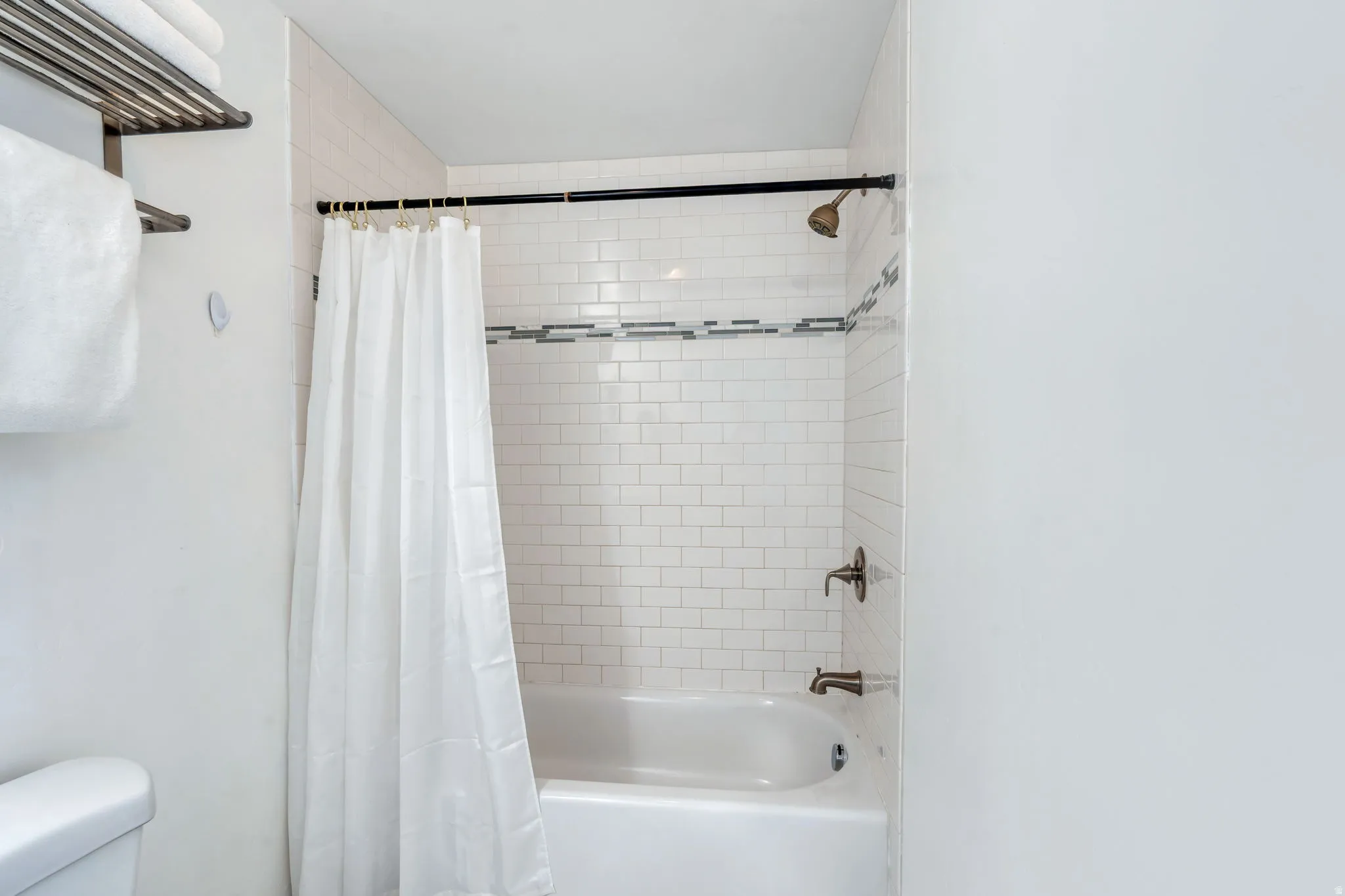 Bathroom featuring toilet and shower / bath combo with shower curtain