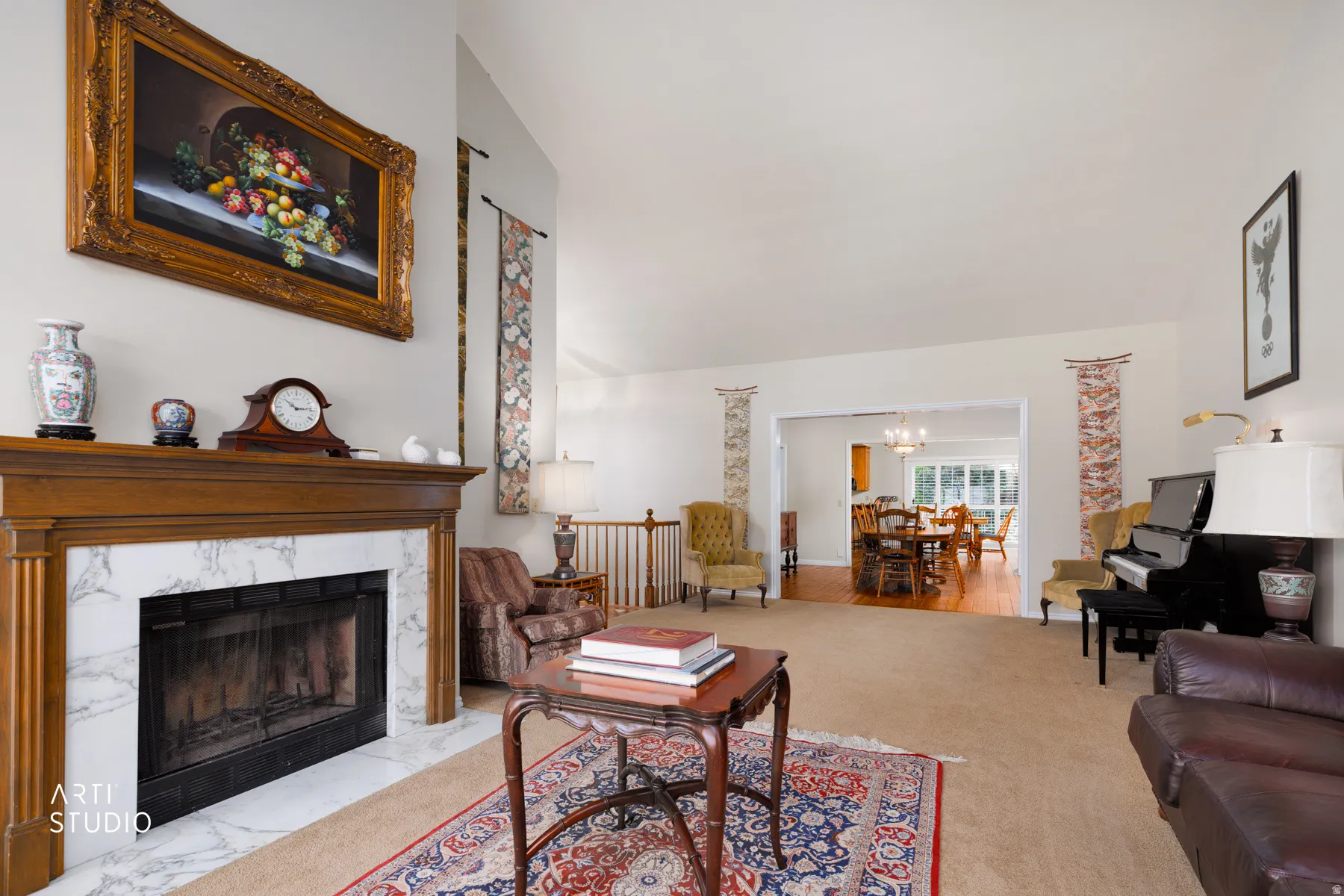 Spacious living area featuring a fireplace with a wood mantel and marble-finish surround, carpet flooring, and a broad entry to a dining space with wood-finish flooring