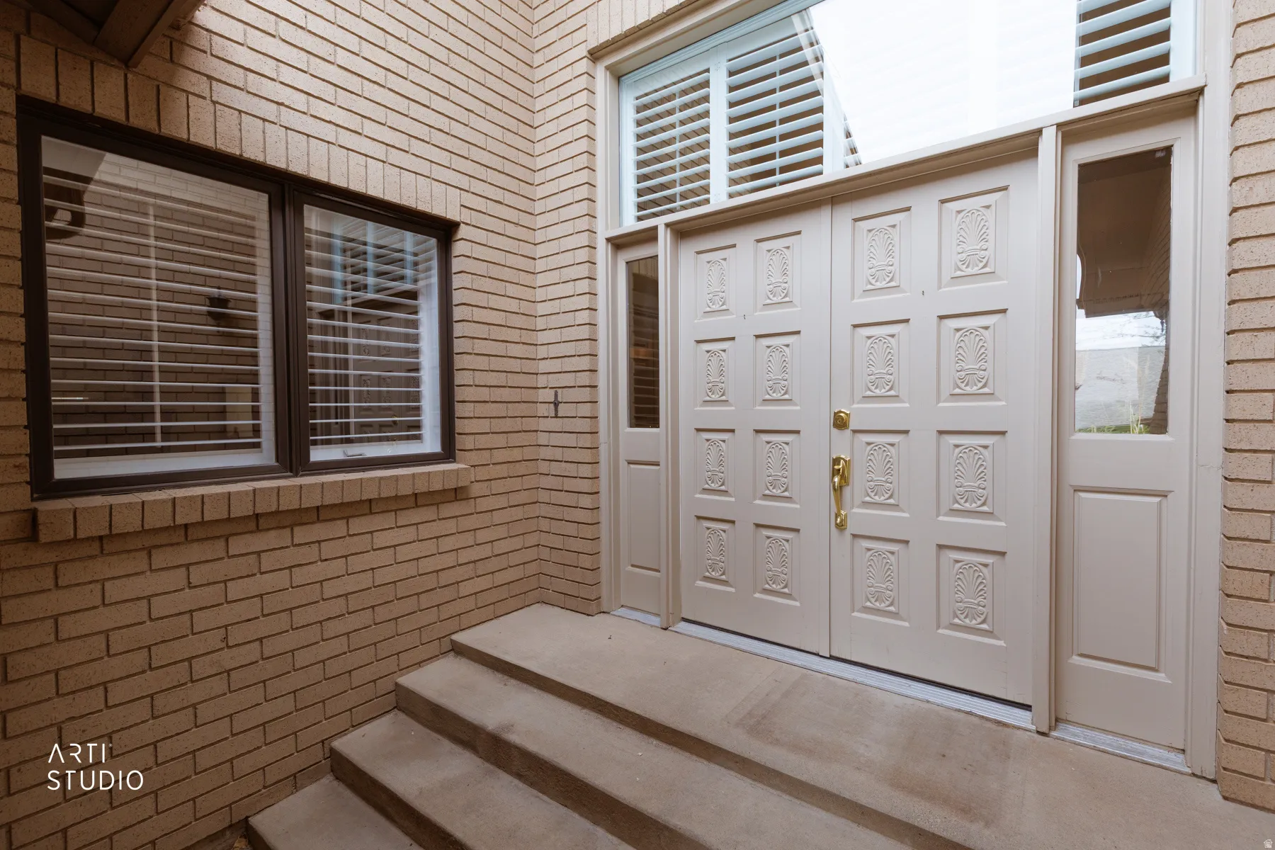 Entryway featuring a double door with decorative panels, sidelights, and a transom window with plantation shutters
