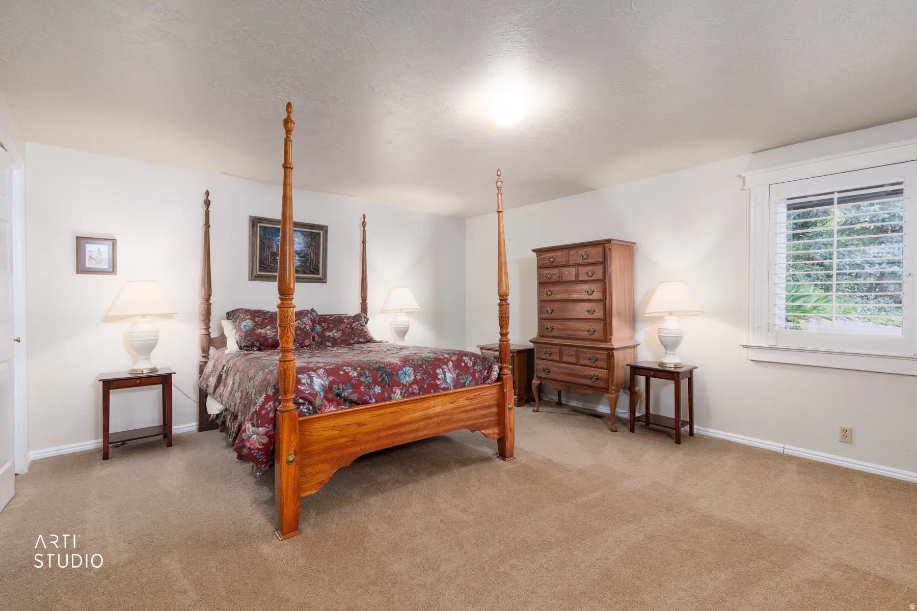 Spacious room featuring neutral carpeting, light-toned walls, and a window with plantation shutters