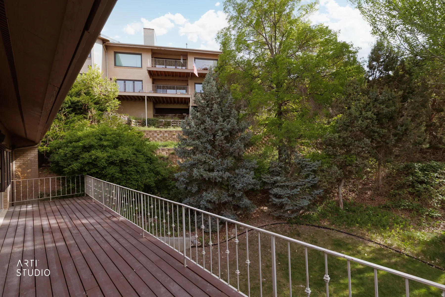 Expansive outdoor deck featuring wood-finish flooring and a decorative metal railing