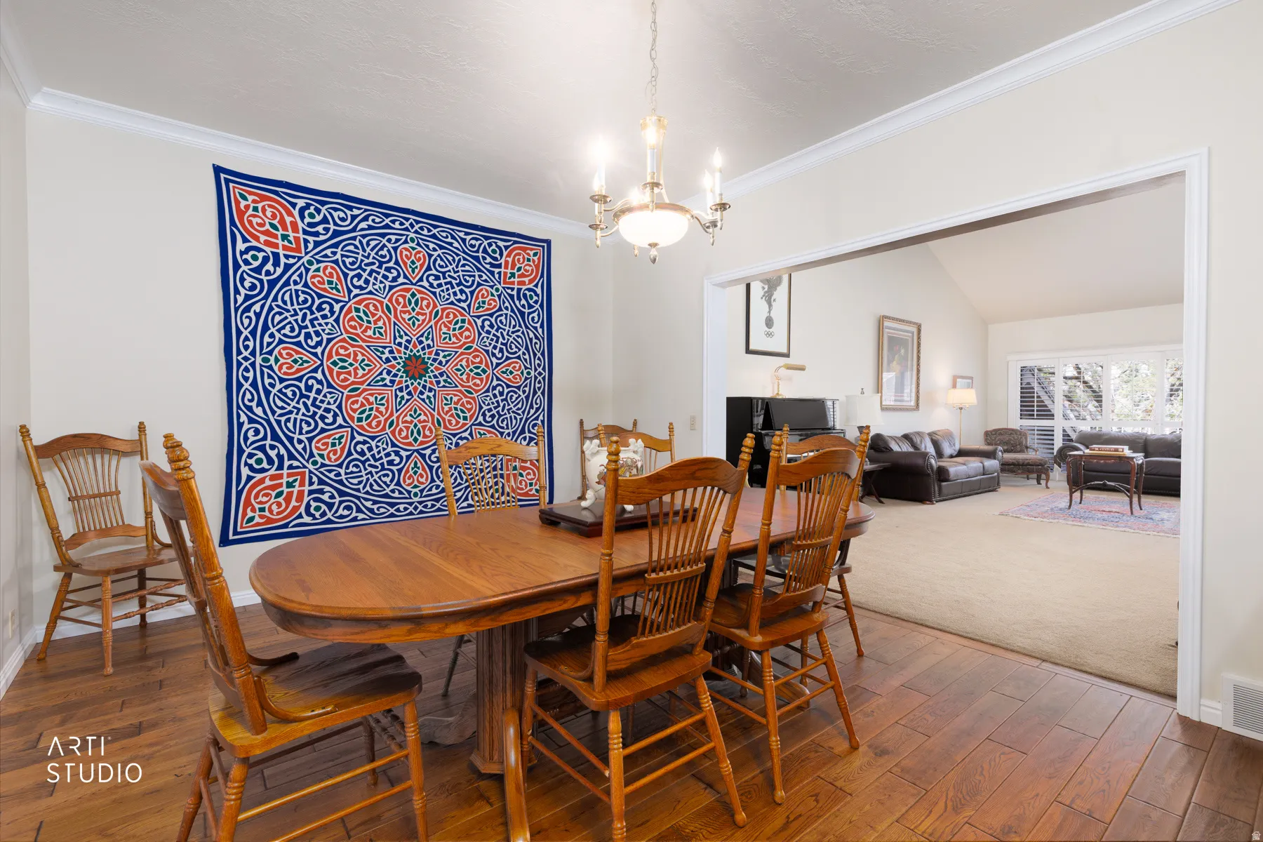 Dining area featuring wood-finish flooring, a chandelier, and crown molding
