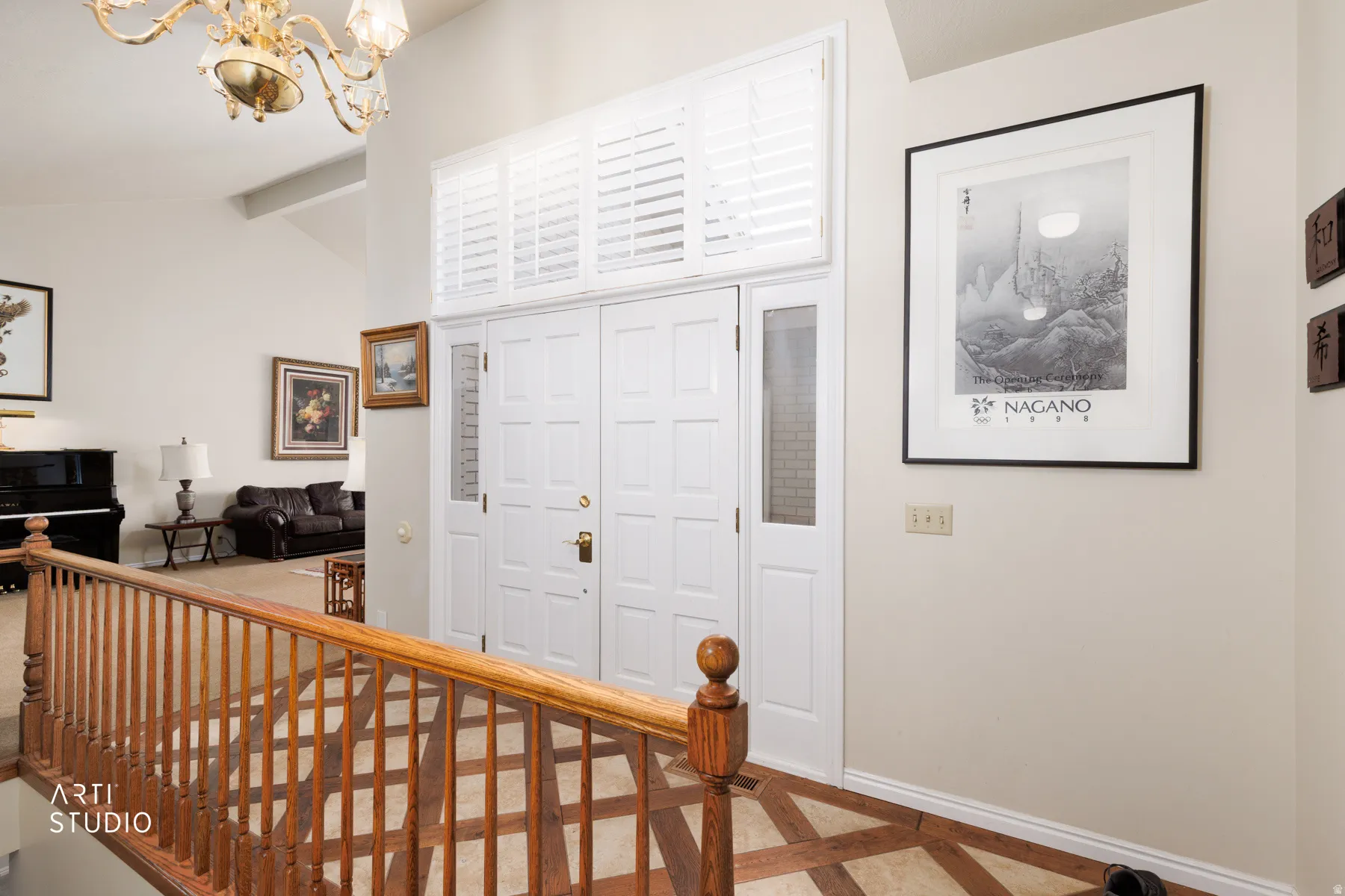Entryway featuring a double door with sidelight, overhead transom windows with plantation shutters, a wood-finish railing, and light-toned walls
