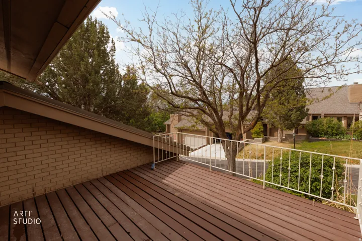 Exterior deck featuring wood-finish flooring and a white metal railing