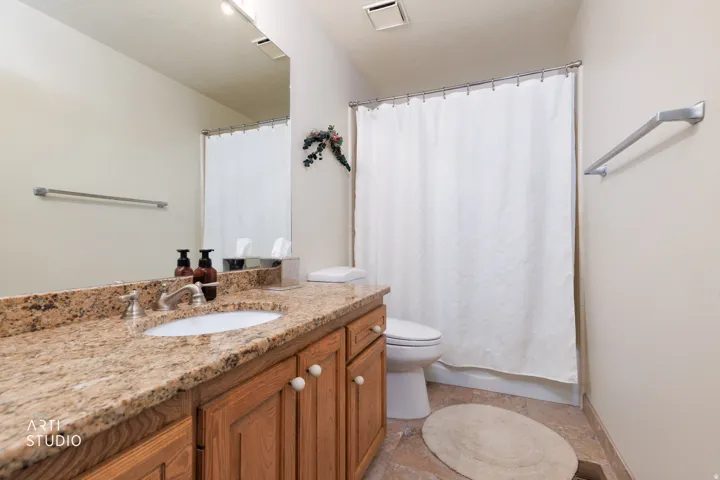 Master bathroom featuring a vanity with granite countertop, integrated sink, and wood cabinetry