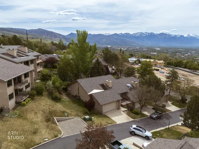 Aerial view of property showing neighborhood and mountain background.