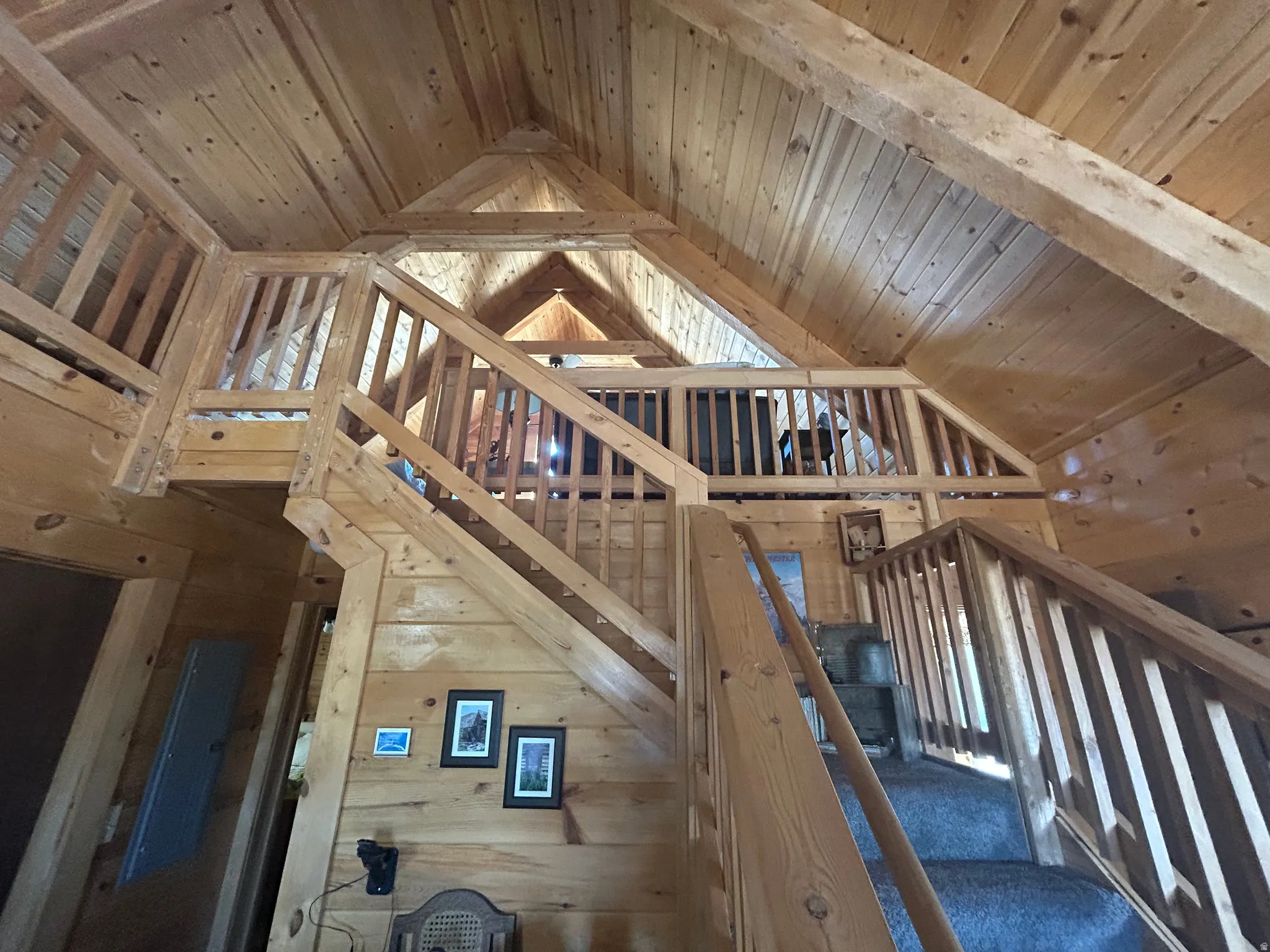 Open-concept interior featuring extensive wood paneling and a multi-level design
