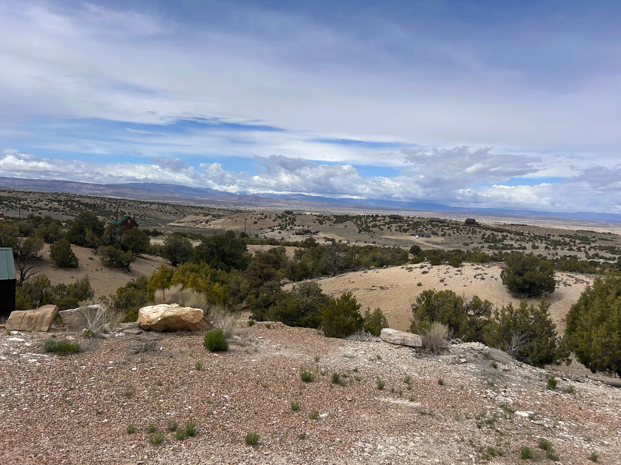 Expansive desert landscape featuring rolling terrain and distant mountain ranges