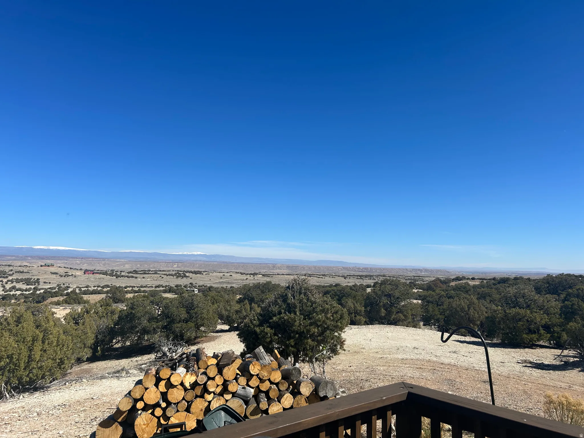 Expansive outdoor panorama featuring distant mountains, a vast landscape of natural terrain, and abundant trees
