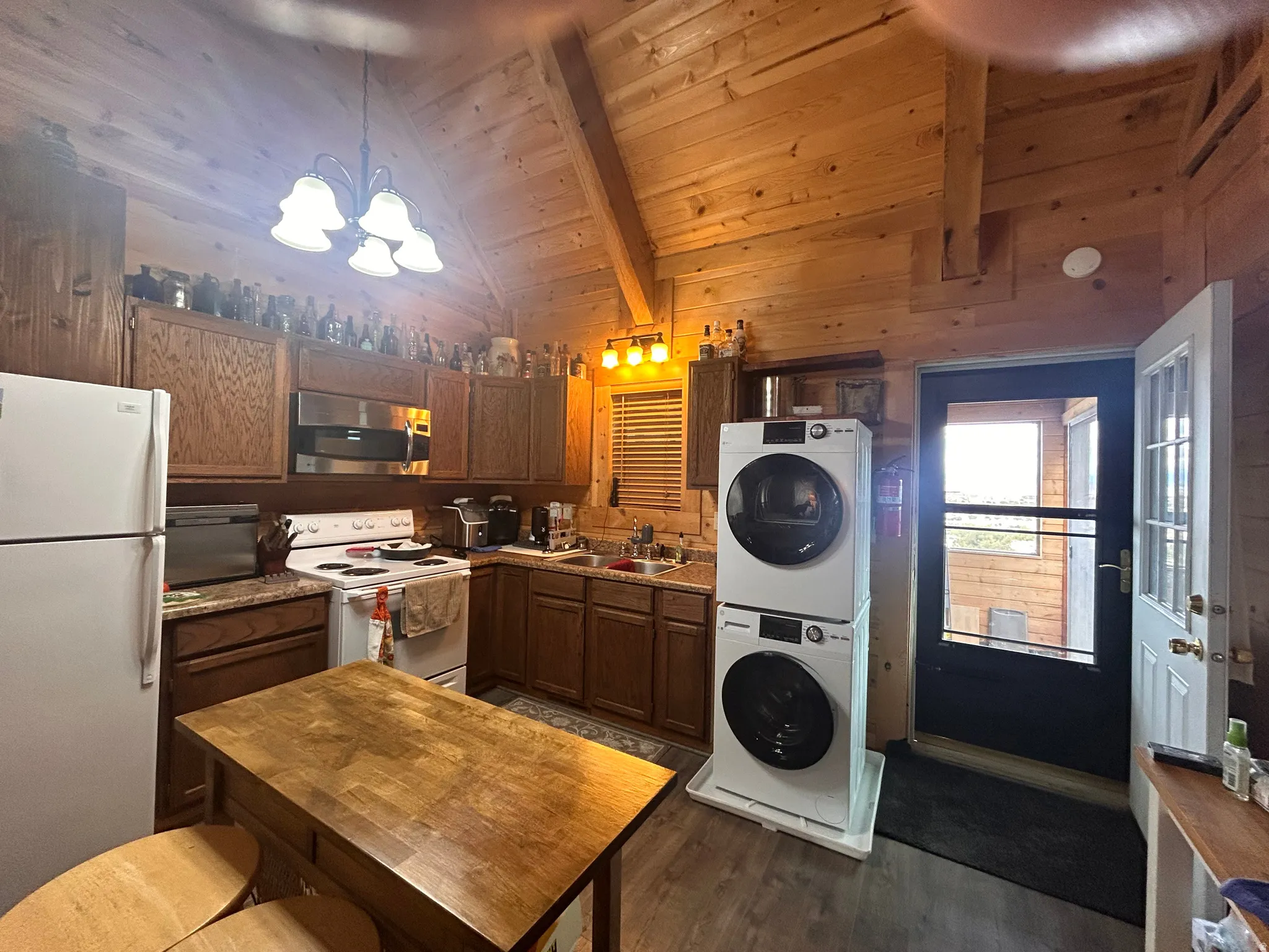 Kitchen featuring wood-finish cabinetry, white appliances, and a wood-finish island