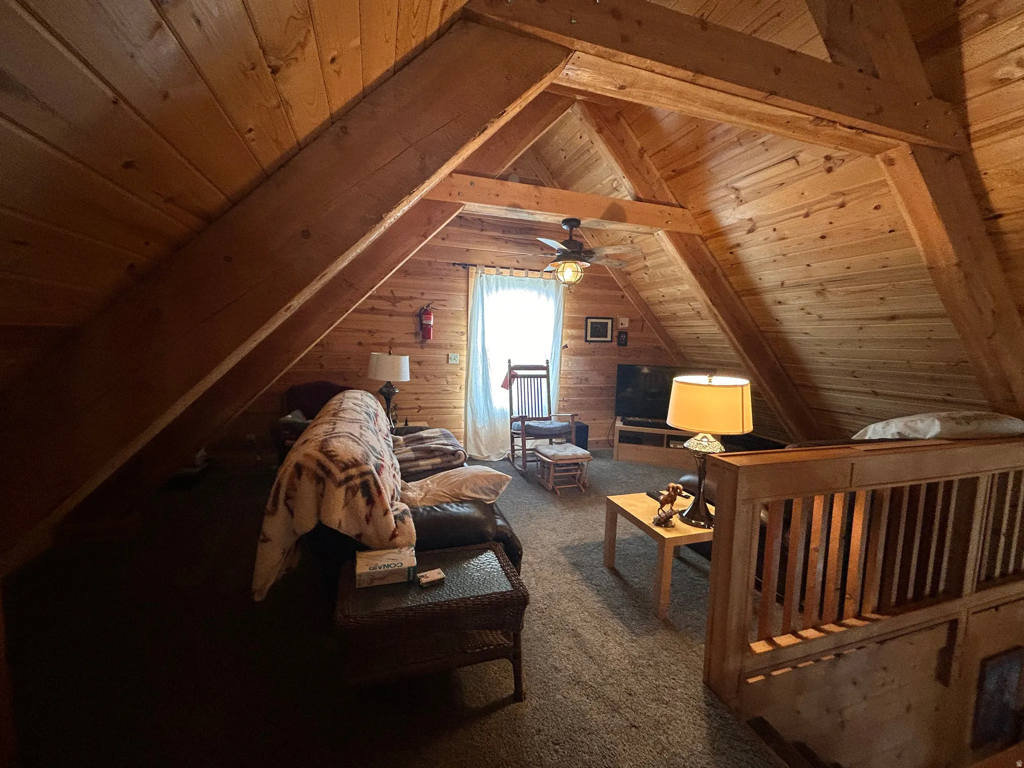 Vaulted wood-paneled ceilings with exposed wooden beams throughout this loft space