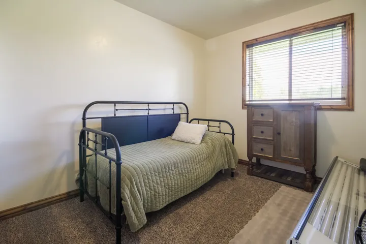 Carpeted room featuring a window with wood trim and blinds