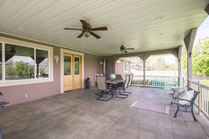 Spacious covered patio featuring a paneled ceiling, recessed lighting, and multiple ceiling fans