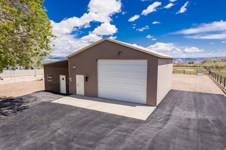 Multi-purpose outbuilding featuring a large roll-up door, two entry doors, and durable exterior finishes