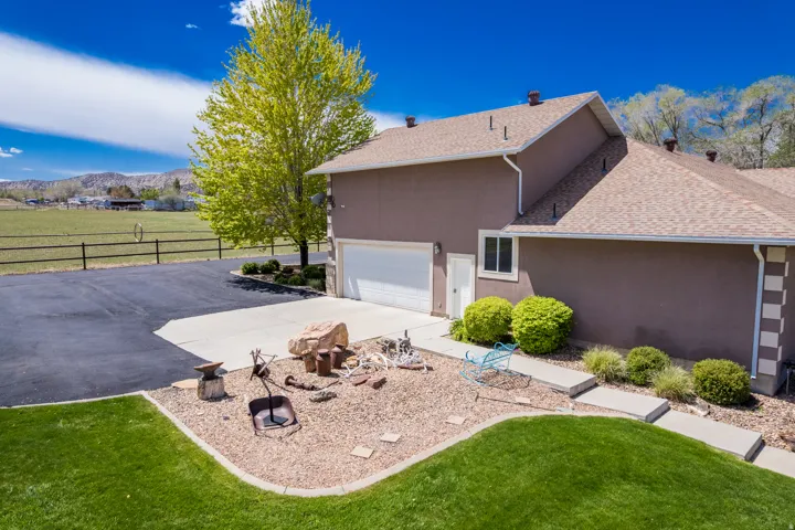 Stucco exterior with an attached garage, asphalt driveway, and concrete walkway