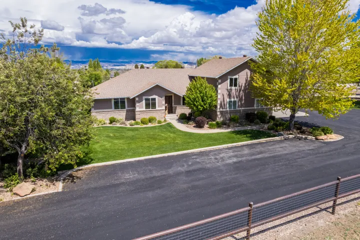 Two-story residence featuring a neutral exterior, stone accents, and a shingled roof
