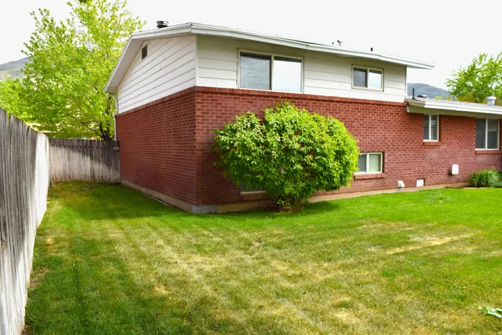 Expansive grassy lawn bordered by a wood fence