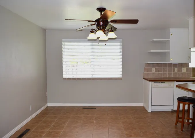 Dinning room featuring a multi-speed ceiling fan, a window with blinds, and tile flooring