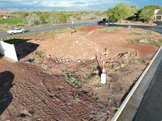 Power available - Graded lot featuring a paved road frontage, established curb, and visible utility connections