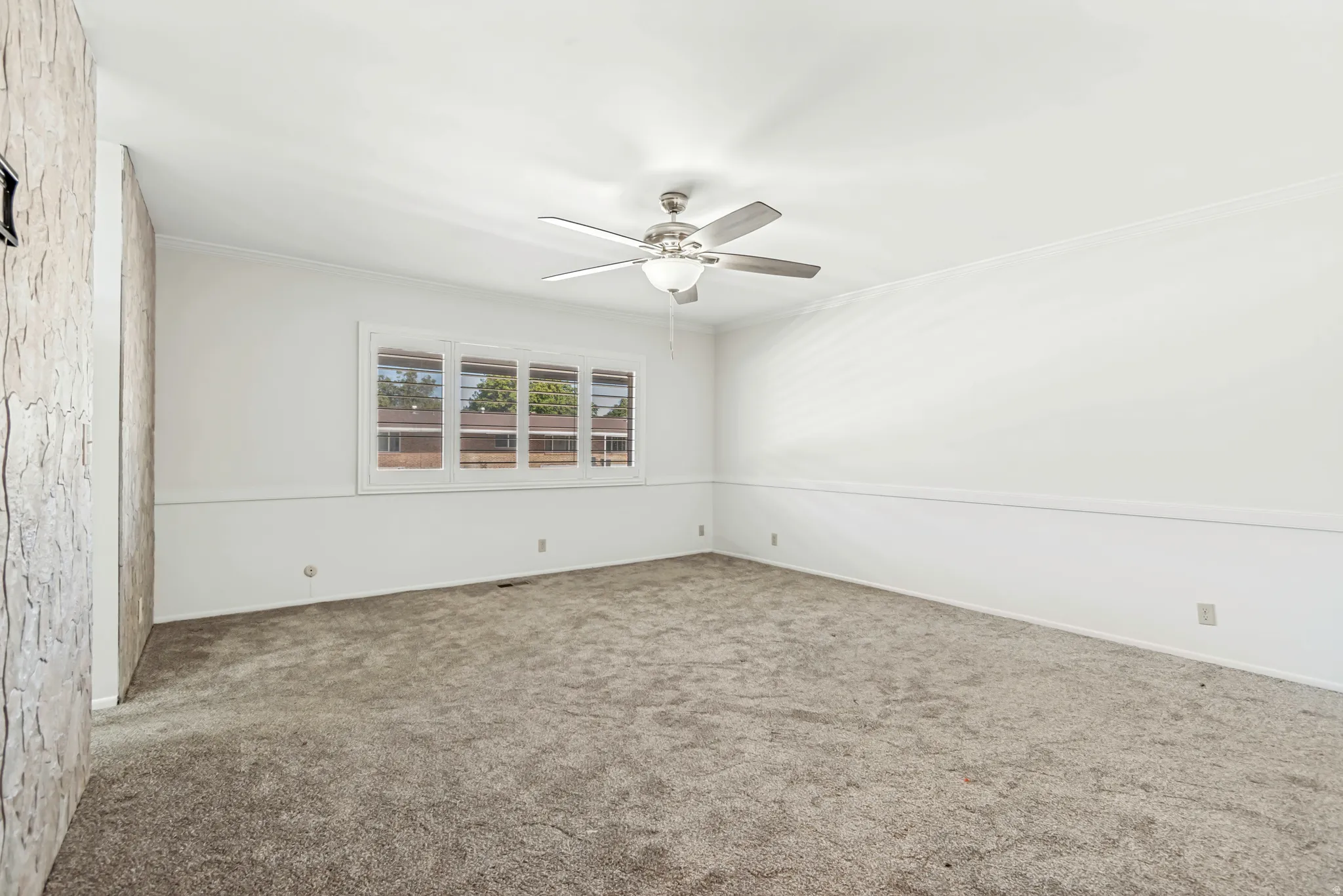 Spacious room featuring gray textured carpet and a multi-pane window