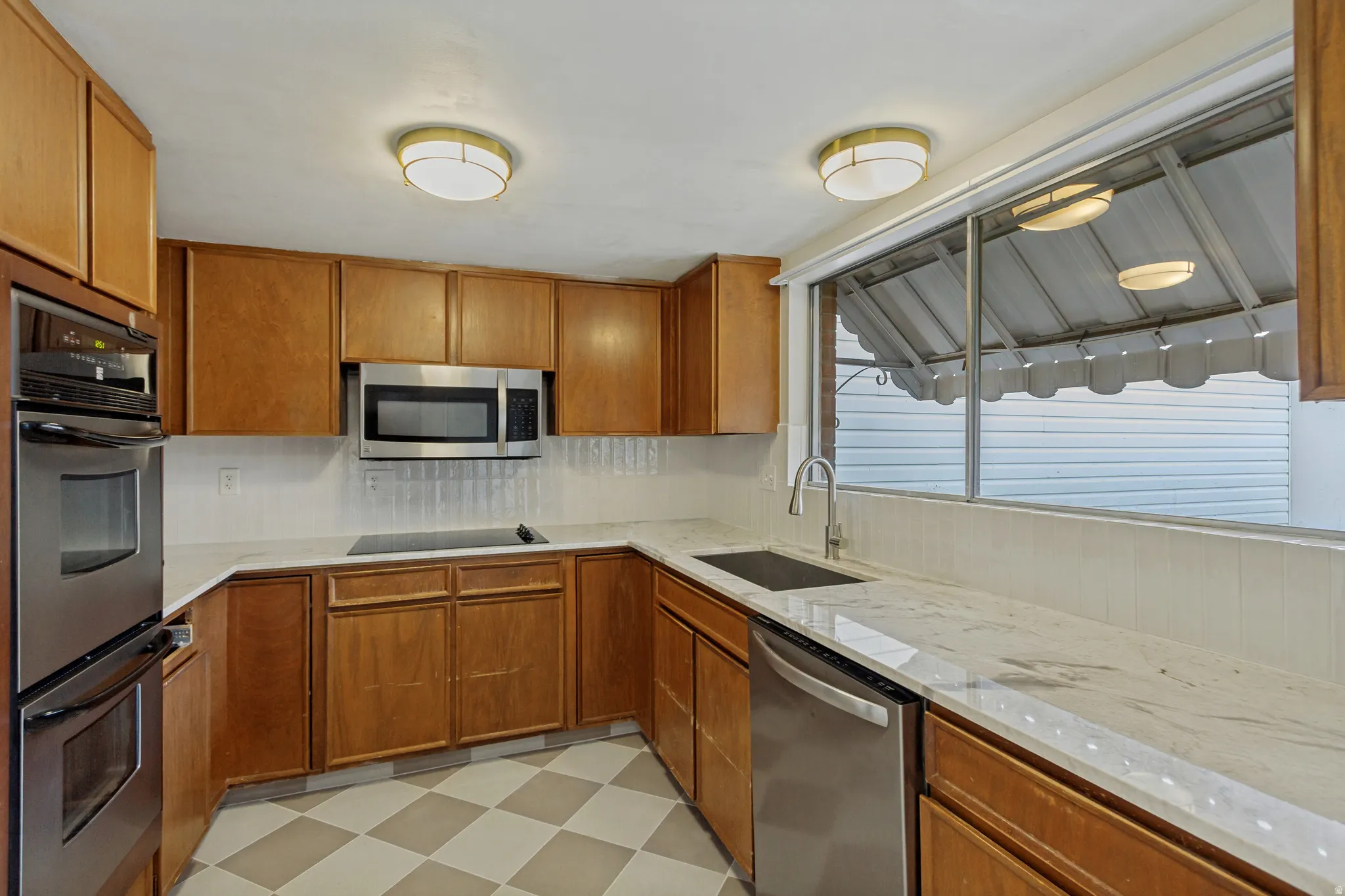 Wood-finish cabinetry paired with light-toned countertops and a tiled backsplash