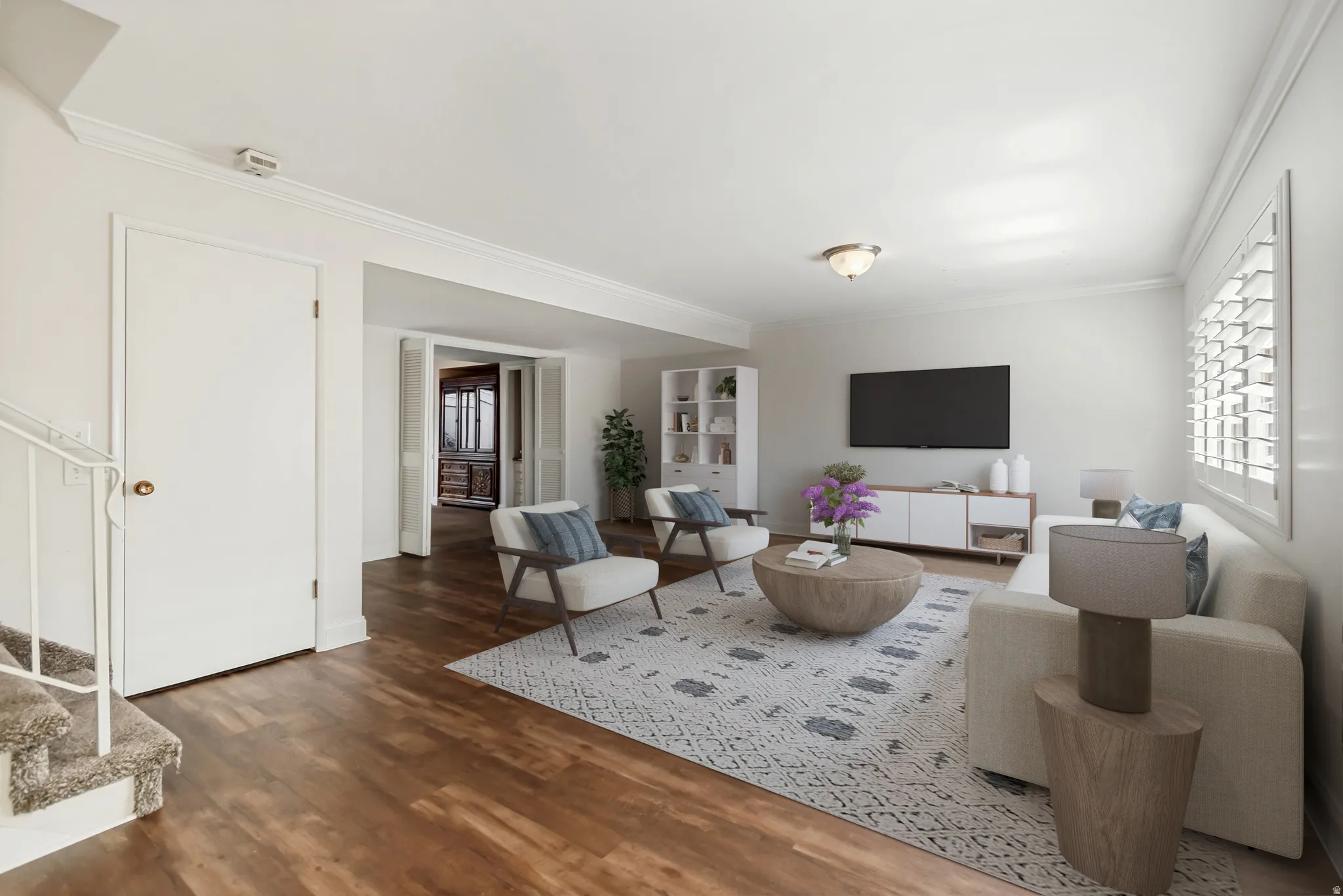 Living area featuring wood-finish flooring, white walls, and crown molding