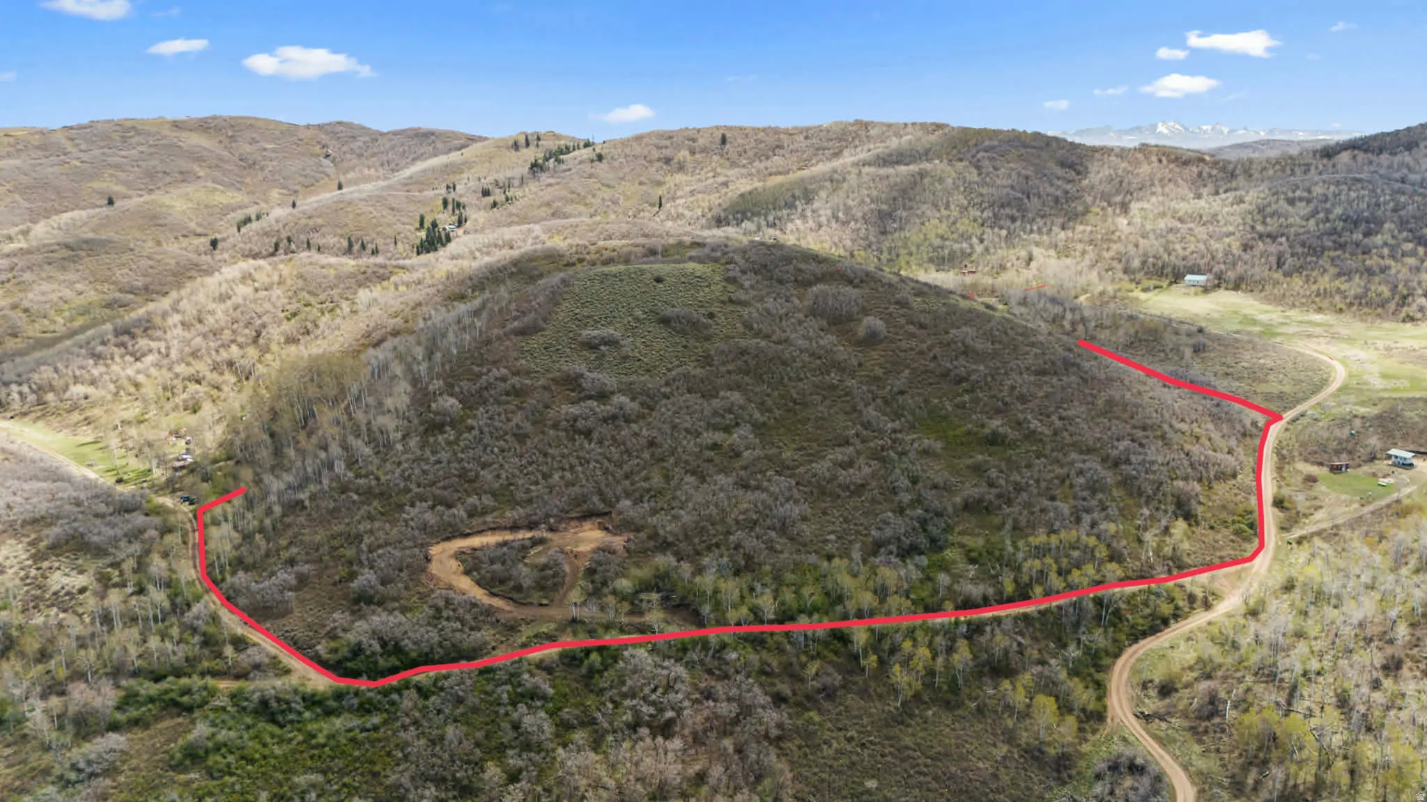 Expansive rolling terrain featuring natural vegetation and distant mountain ranges