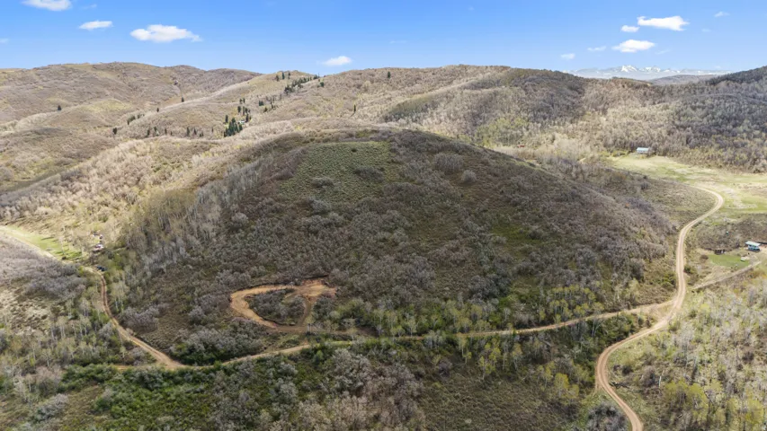 Expansive natural landscape featuring rolling hills and sparse vegetation