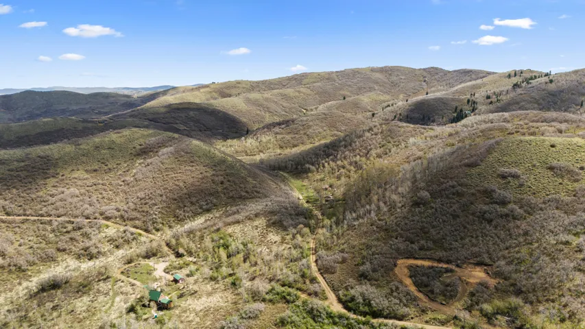 Expansive mountain landscape featuring rolling hills and varied vegetation