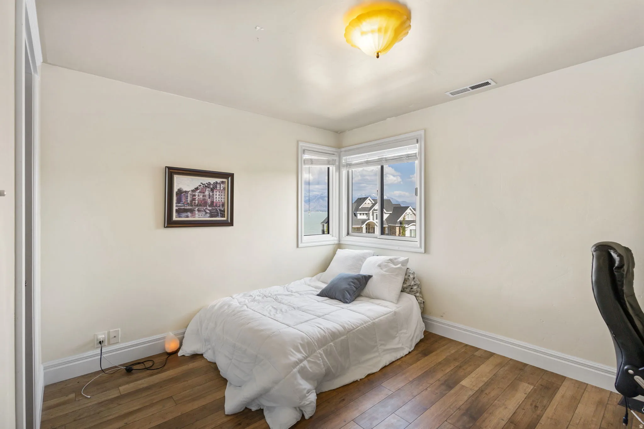 Bedroom with baseboards and dark wood-type flooring