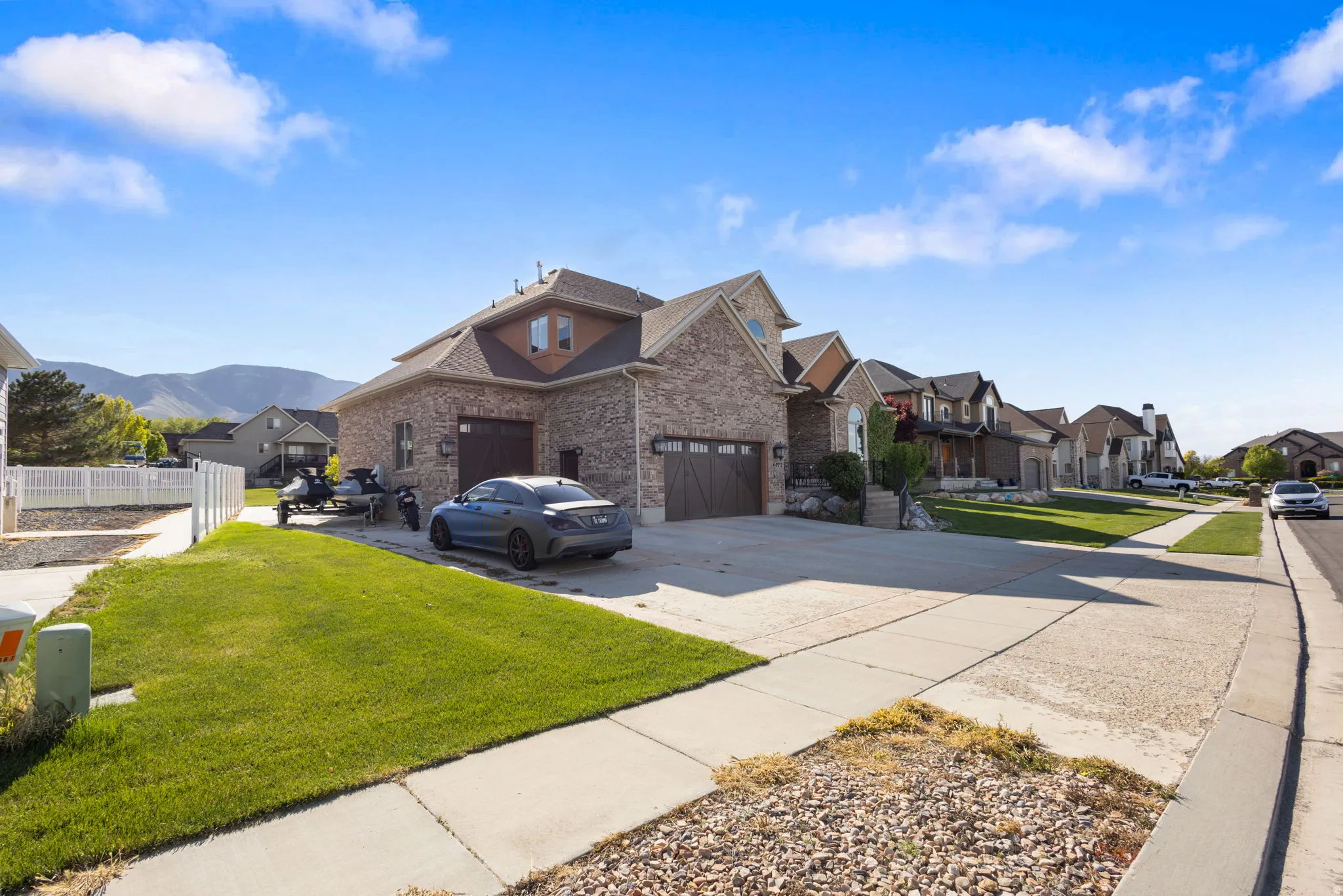 Traditional home with concrete driveway, a residential view, a front lawn, and brick siding