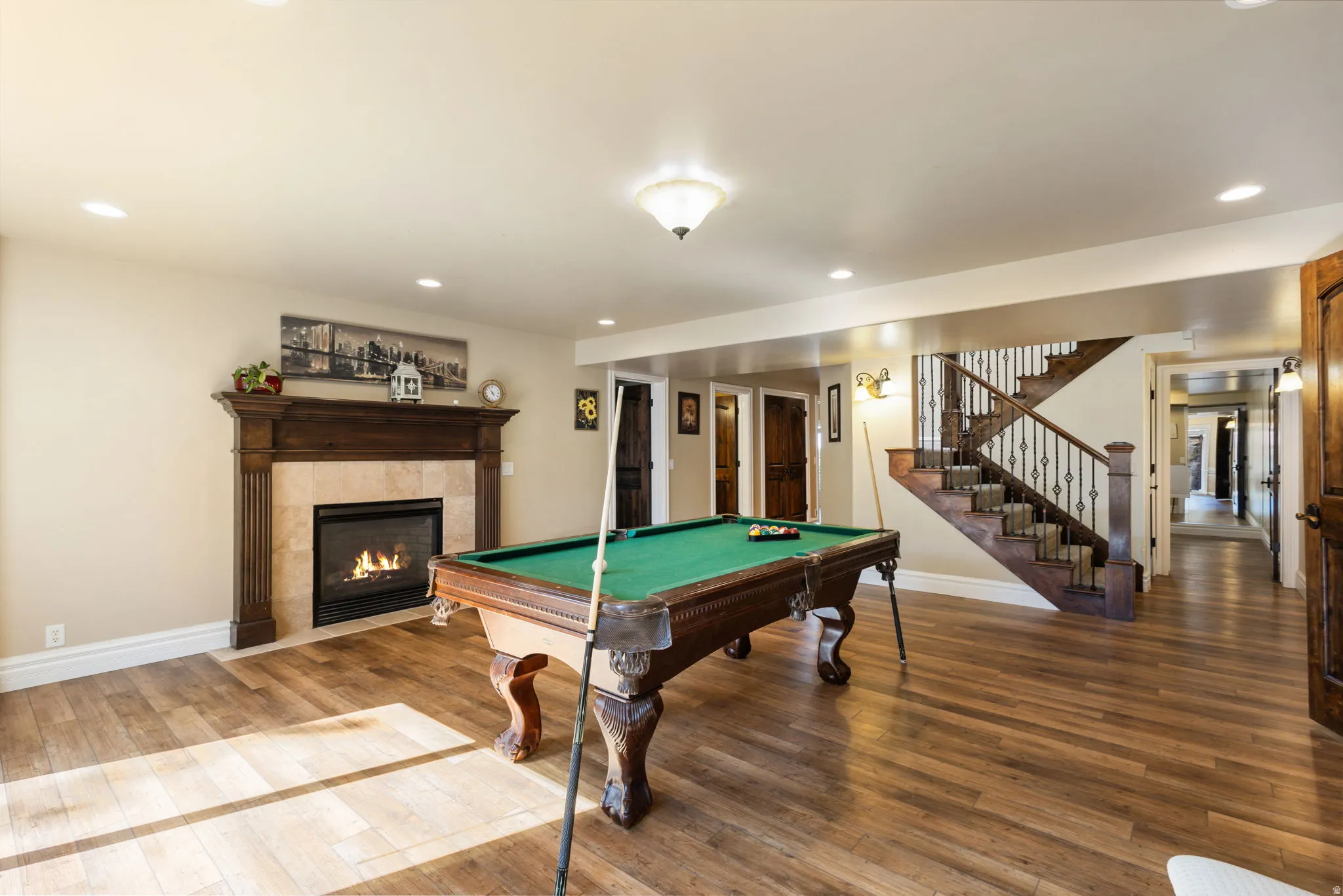 Game room with wood-type flooring, recessed lighting, billiards table, and a tile fireplace