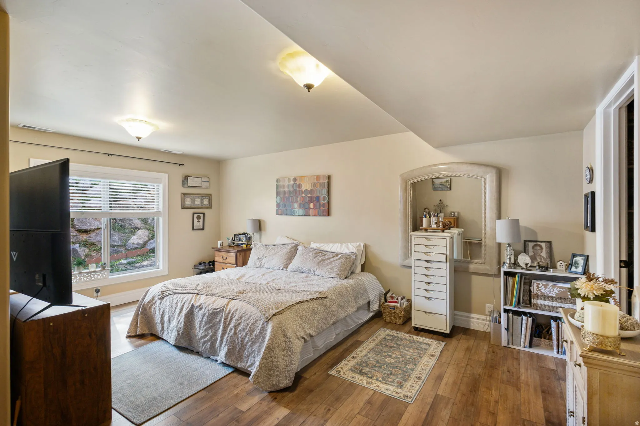 Bedroom with dark wood finished floors and baseboards