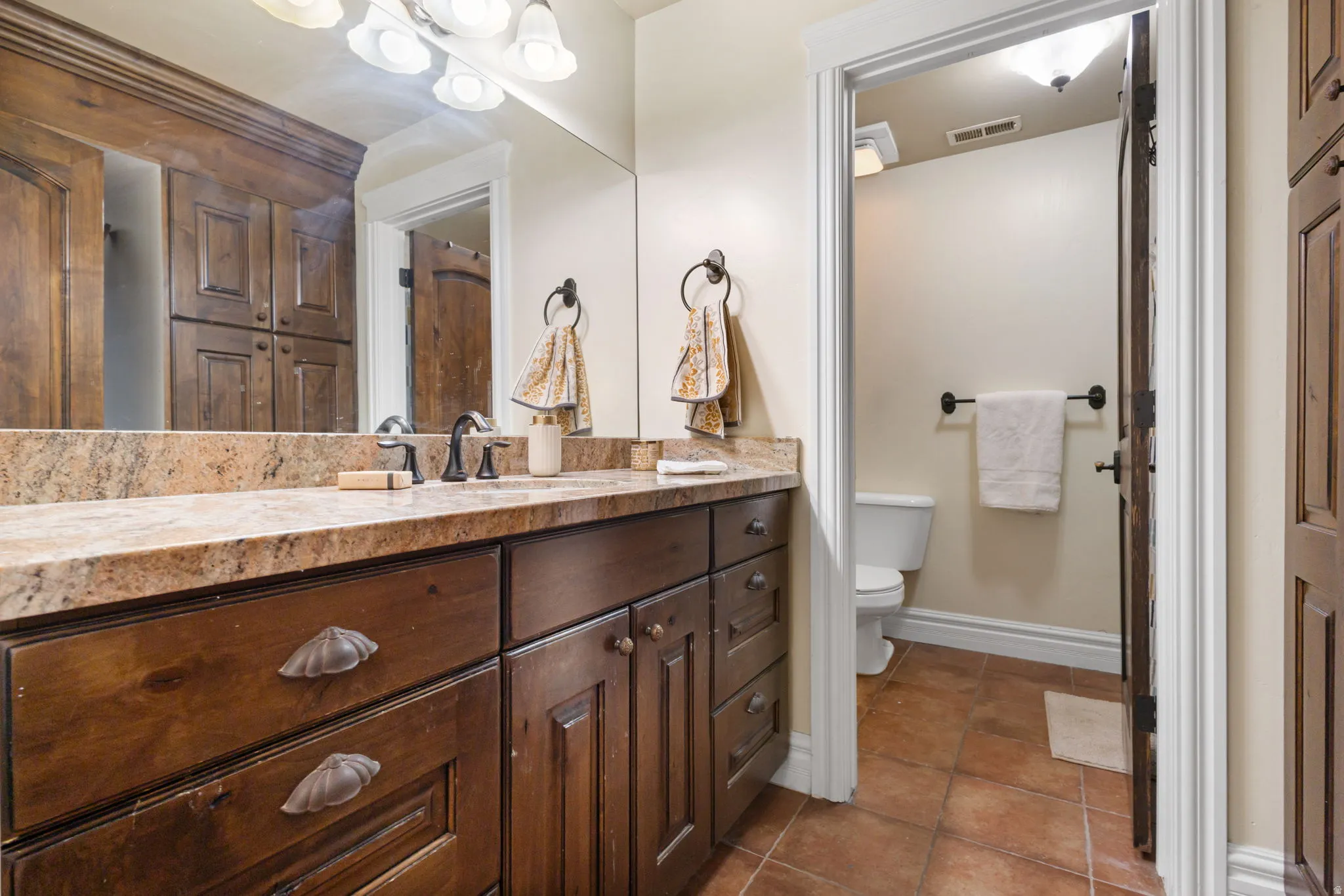 Full bathroom with vanity and dark tile patterned flooring