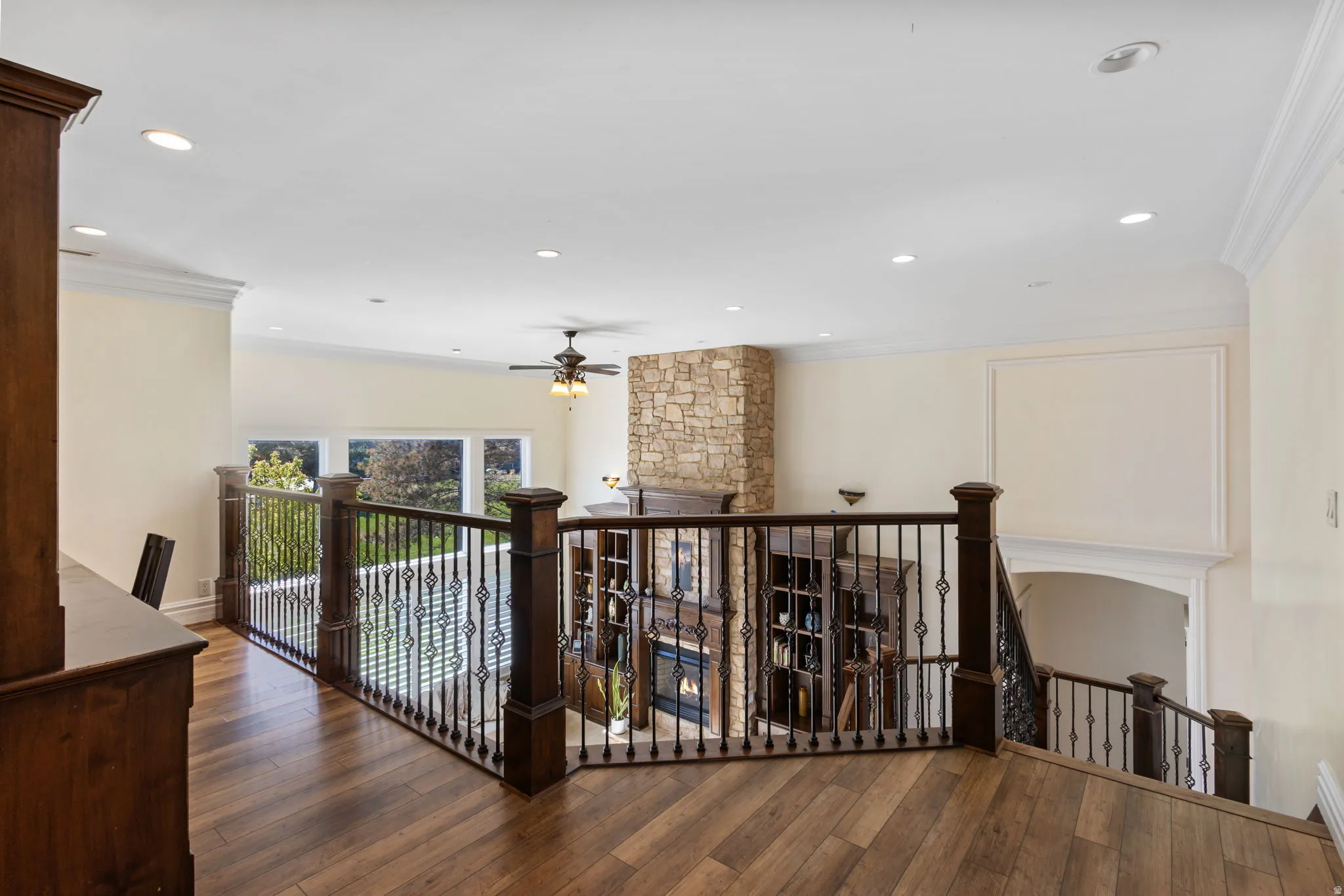 Hall with an upstairs landing, ornamental molding, wood-type flooring, and recessed lighting