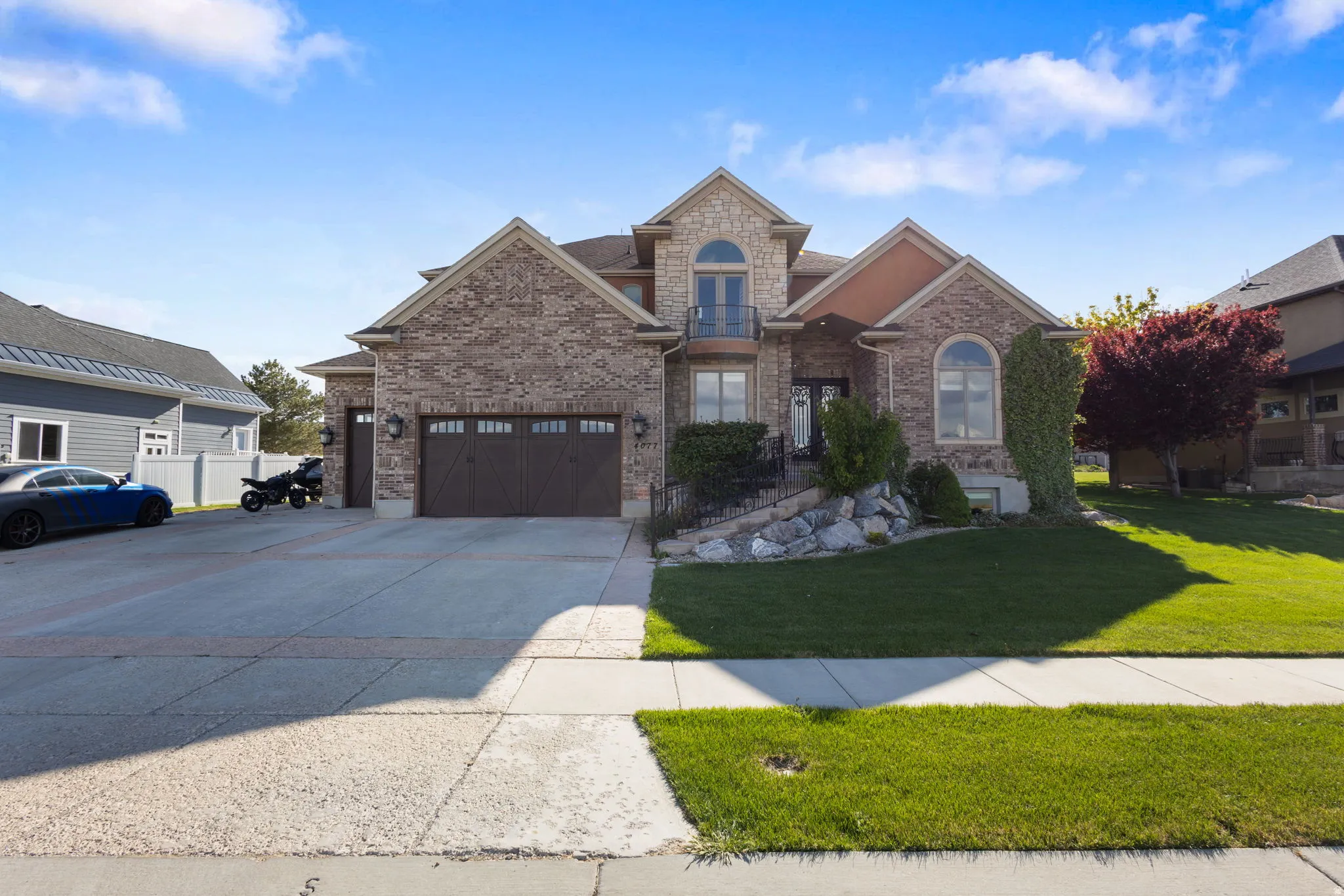View of front of home with a garage, brick siding, a front lawn, and driveway