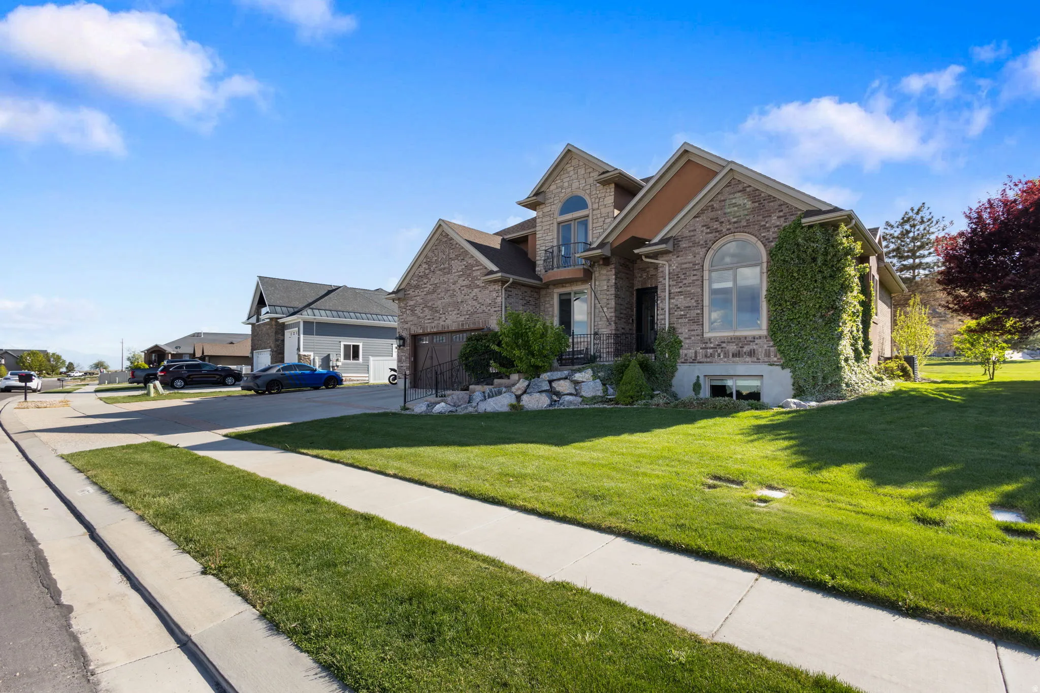 View of front of house with stone siding, a front lawn, a garage, and brick siding
