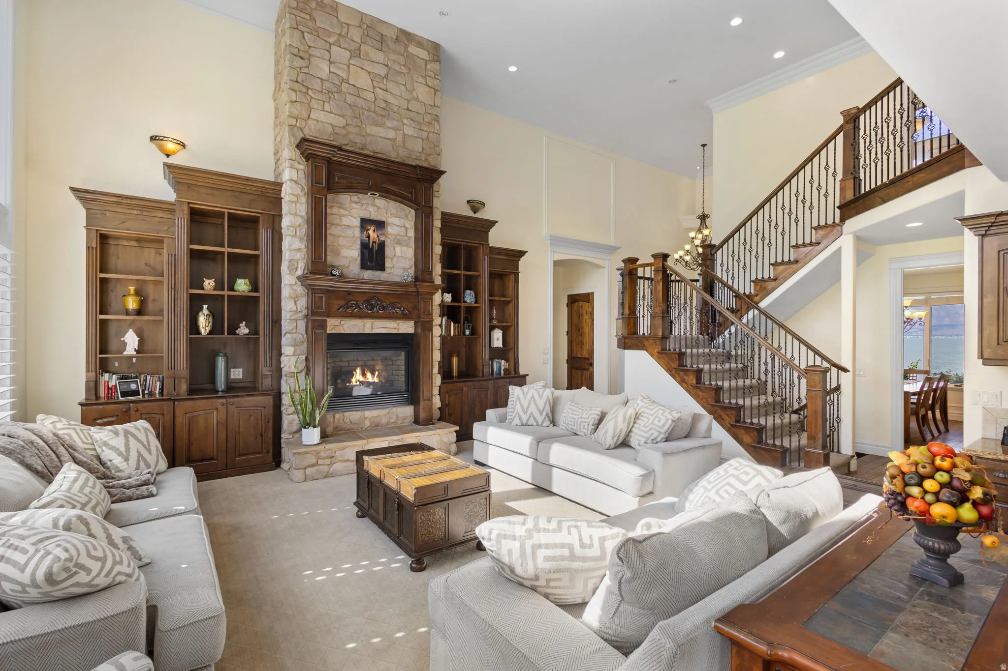 Living room featuring a high ceiling, a fireplace, recessed lighting, and crown molding