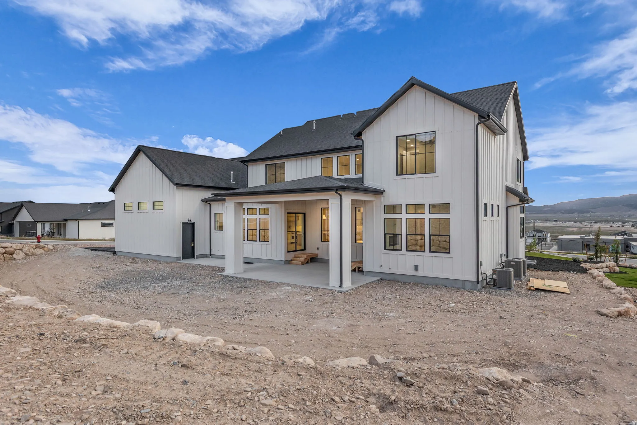 Modern farmhouse exterior featuring white vertical siding and dark-trimmed windows