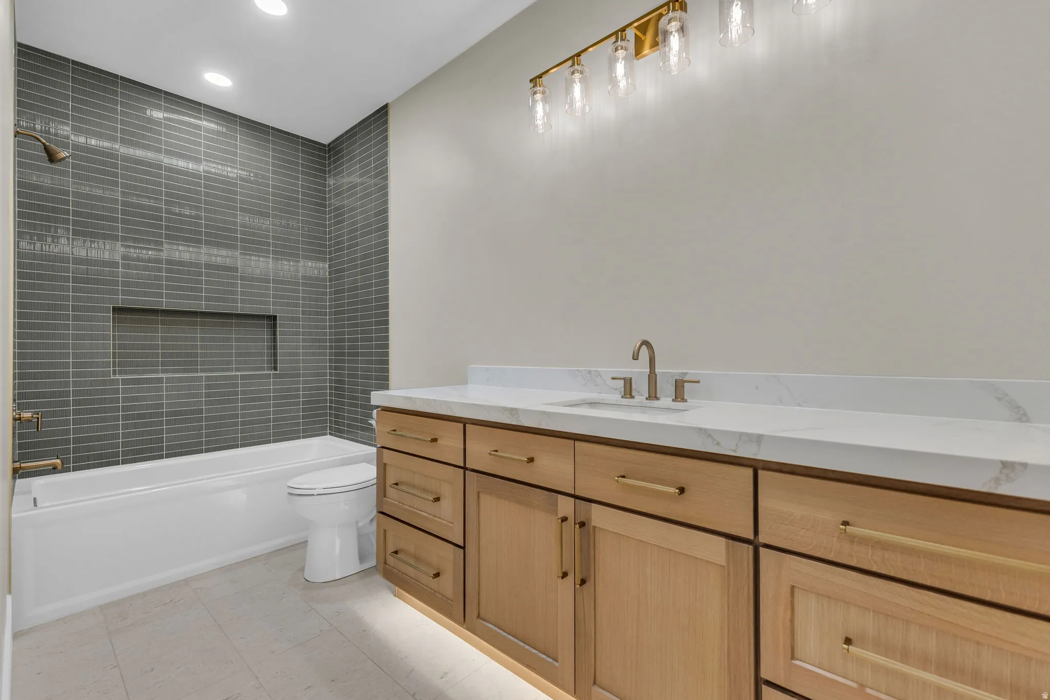 Light wood-finish vanity with ample storage, a white countertop, and a built-in sink