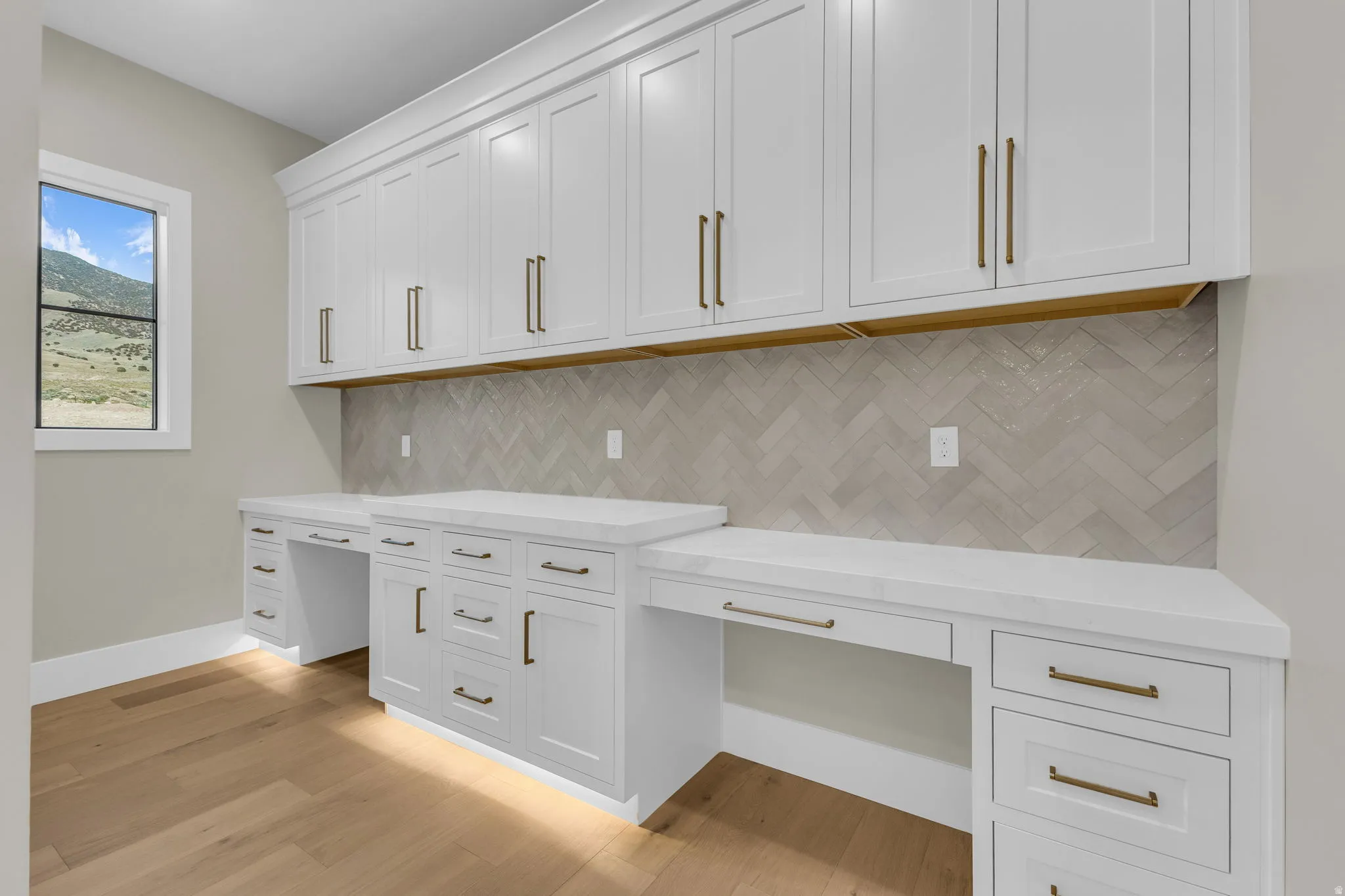 Built-in cabinetry featuring white shaker-style doors and brass hardware