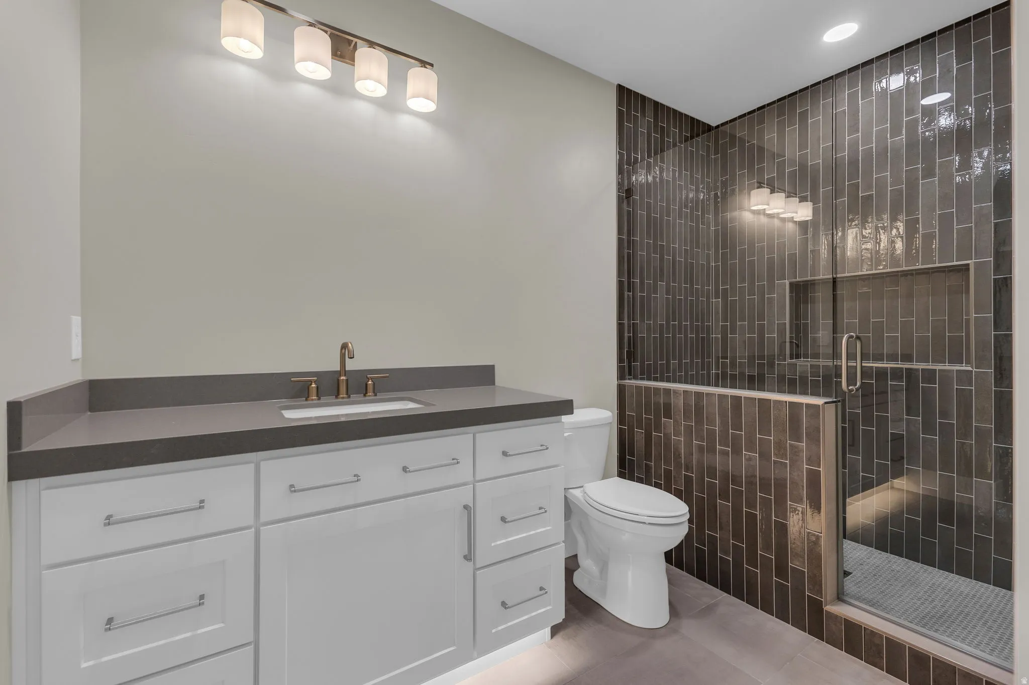 Contemporary bathroom featuring a spacious white vanity with a dark countertop and an undermount sink