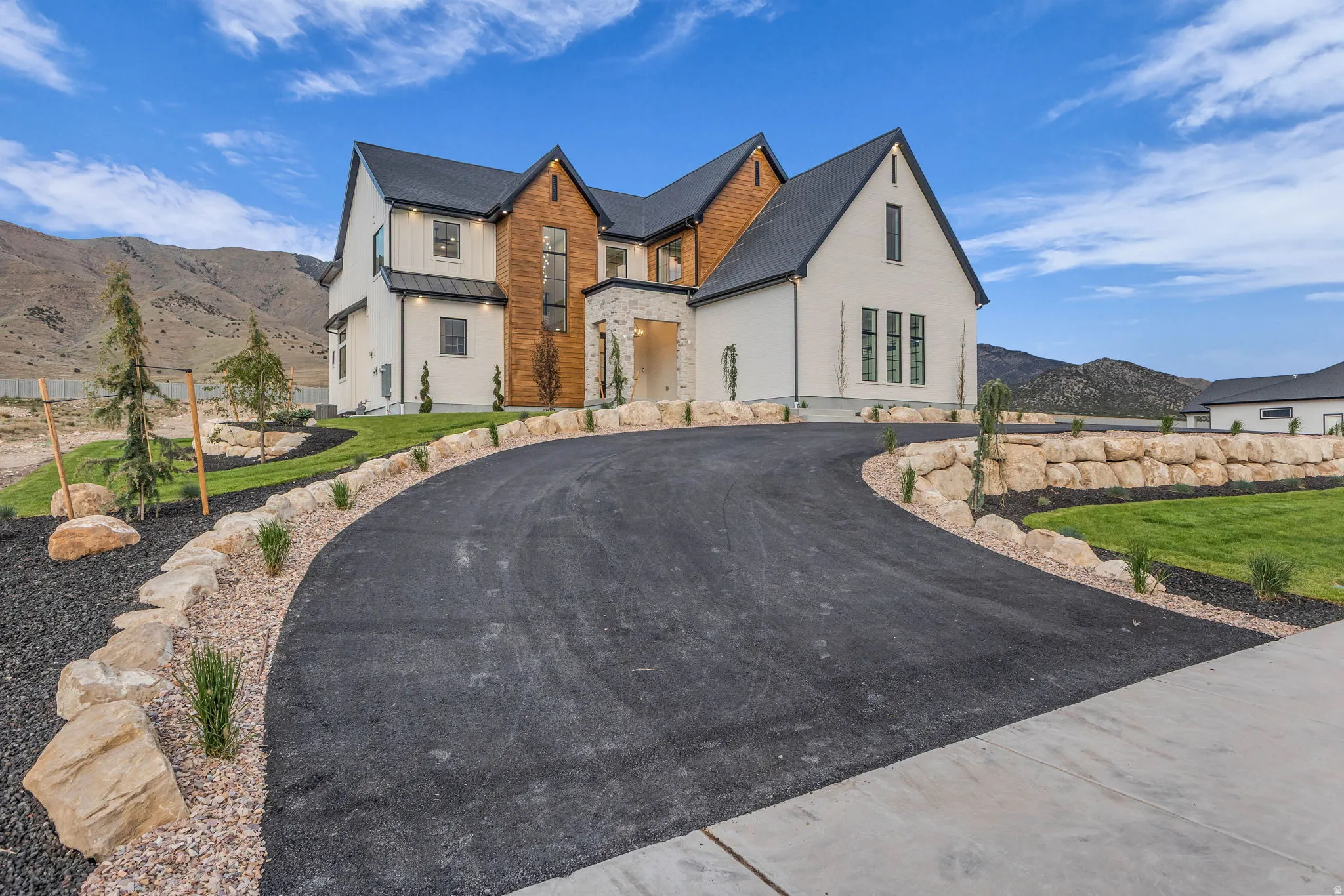 Contemporary exterior featuring white siding, dark gabled rooflines, and a wood-paneled accent wall