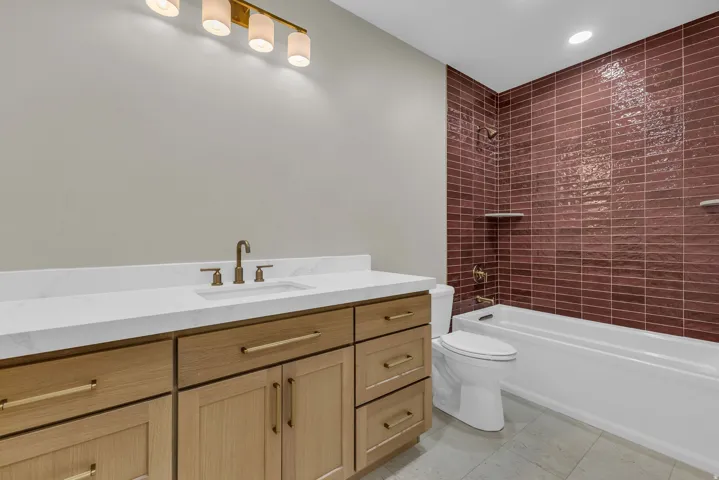 Bathroom featuring a light wood-finish vanity with a white countertop and integrated sink