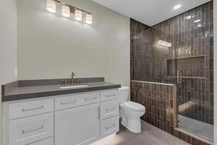 Contemporary bathroom featuring a spacious white vanity with a dark countertop and an undermount sink