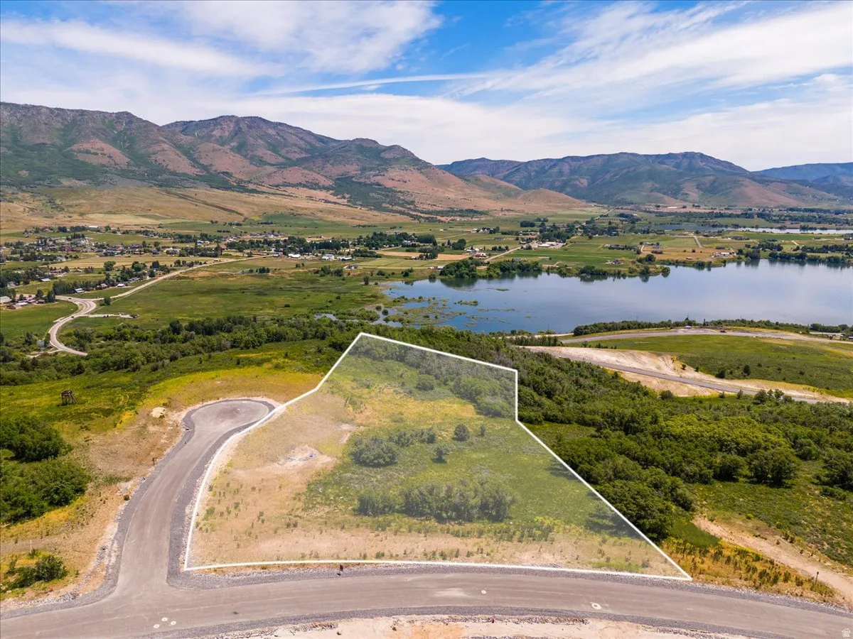 Aerial view of property and surrounding area with property boundaries highlighted and a water and mountain view